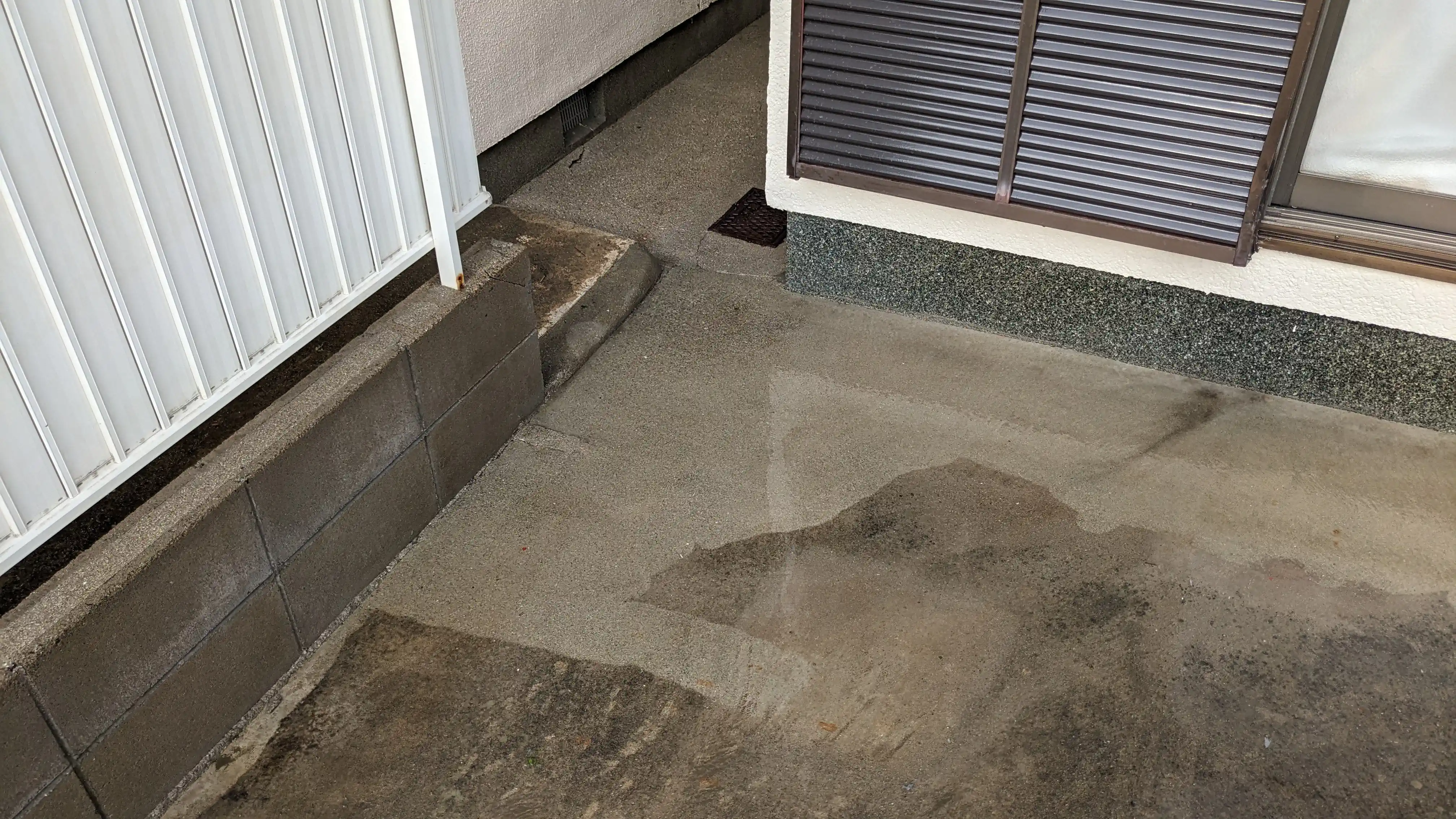 Concrete driveway and low wall rinsed after pressure washing at a Japanese house